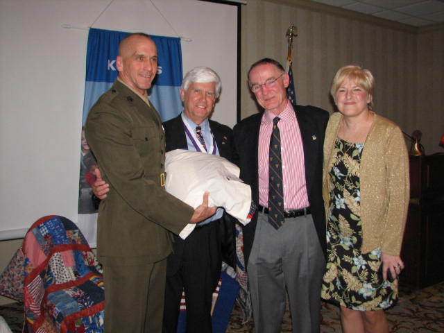 IMG_1696.JPG - As the ceremony closed, Brigadier General Richard Simcock was presented a Quilt Of Valor by Kathy Thorne of the MSP Quilting Angels on behalf of their organization and Kiwanis for his support of our Wounded Warriors. From left to right, Brigadier General Simcock, Past Capital District Kiwanis Governor Bob Cressy, Navy Captain and Master of Ceremonies, President Elect Mike Cronin, and Kathy Thorne of the MSP Quilting Angels. This was a marvelous, moving evening. See you next year! God Bless America!